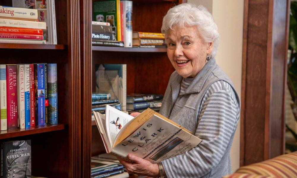 Independent senior near Roseville selecting a book